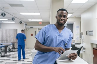 Portrait of smiling doctor using digital tablet in hospital