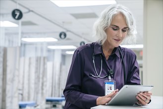 Caucasian doctor using digital tablet in hospital