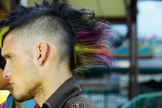 Profile of Hispanic male punk with mohawk hairstyle outdoors