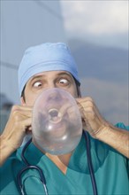 Hispanic doctor blowing up condom