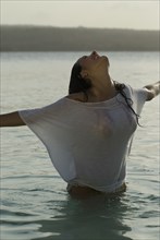 Hispanic woman wearing shirt in water