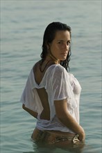 Hispanic woman wearing shirt in water