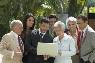 Group of Hispanic businesspeople looking at laptop