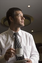 Hispanic businessman drinking coffee