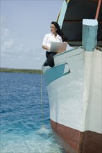 Hispanic businesswoman working on boat