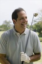 Hispanic man holding golf club