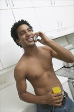 Bare-chested African man talking on cell phone