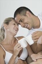 Hispanic couple toasting coffee cups
