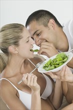 Hispanic man feeding girlfriend salad
