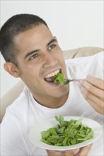 Hispanic man eating salad
