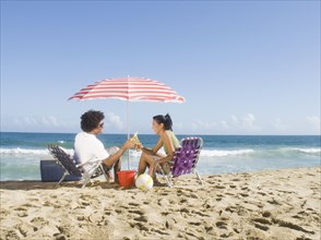 Multi-ethnic couple relaxing at beach