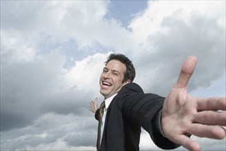 Hispanic businessman with arms outstretched