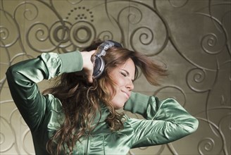 Hispanic woman in headphones dancing