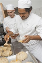 Bakers preparing bread in bakery kitchen