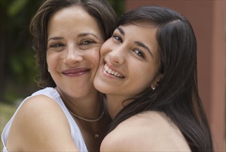 Hispanic mother and daughter hugging