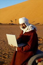 Man using laptop in desert