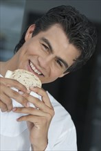 Hispanic man eating sandwich