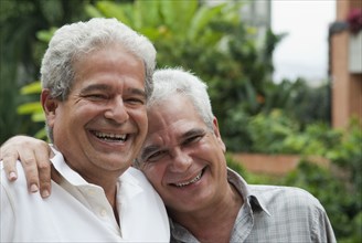 Smiling Hispanic men hugging
