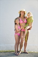 Caucasian mother and daughters smiling on beach