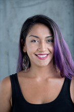 Portrait of smiling Hispanic woman with purple hair