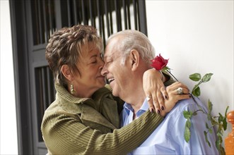 Senior Hispanic woman kissing husband