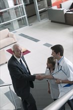 Hispanic businessman shaking hands with doctor on staircase