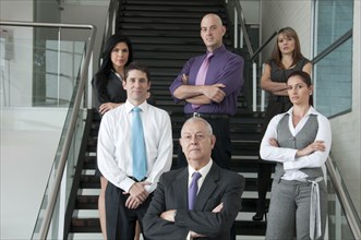 Hispanic business people standing together on staircase