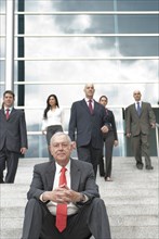 Hispanic business people standing on stairs together outdoors