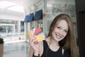Hispanic woman holding credit cards in mall