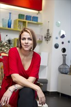 Hispanic business owner sitting in store