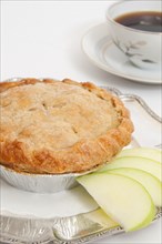 Small apple pie and cup of coffee