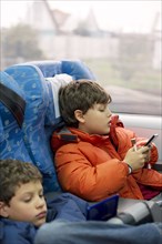 Hispanic brothers playing video games on train