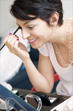 Smiling woman applying make up