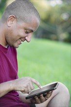Hispanic man using tablet computer