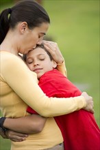Hispanic mother hugging son