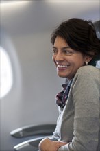 Hispanic woman sitting in airplane