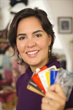 Hispanic woman holding credit cards in shop
