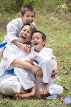 Hispanic family wearing martial arts robes in grass
