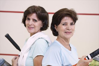 Older Hispanic twins playing squash