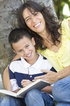 Hispanic mother and son reading book