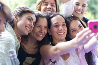 Hispanic women taking selfie at family reunion