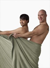 Nude men holding towel open