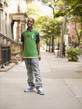 African teenage boy smiling in urban setting