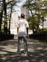 African teenage boy standing in urban park