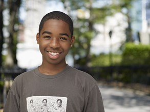 Smiling African teenage boy in urban park