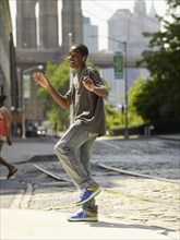 African boy dancing to music in urban setting
