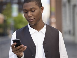 African man text messaging on cell phone