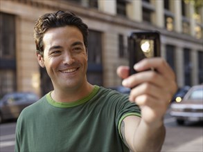 Man taking photograph with cell phone