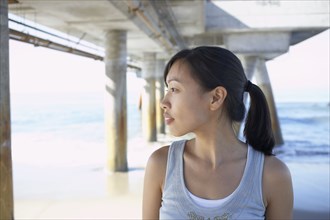 Asian woman under pier at beach