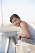 Asian woman leaning on railing